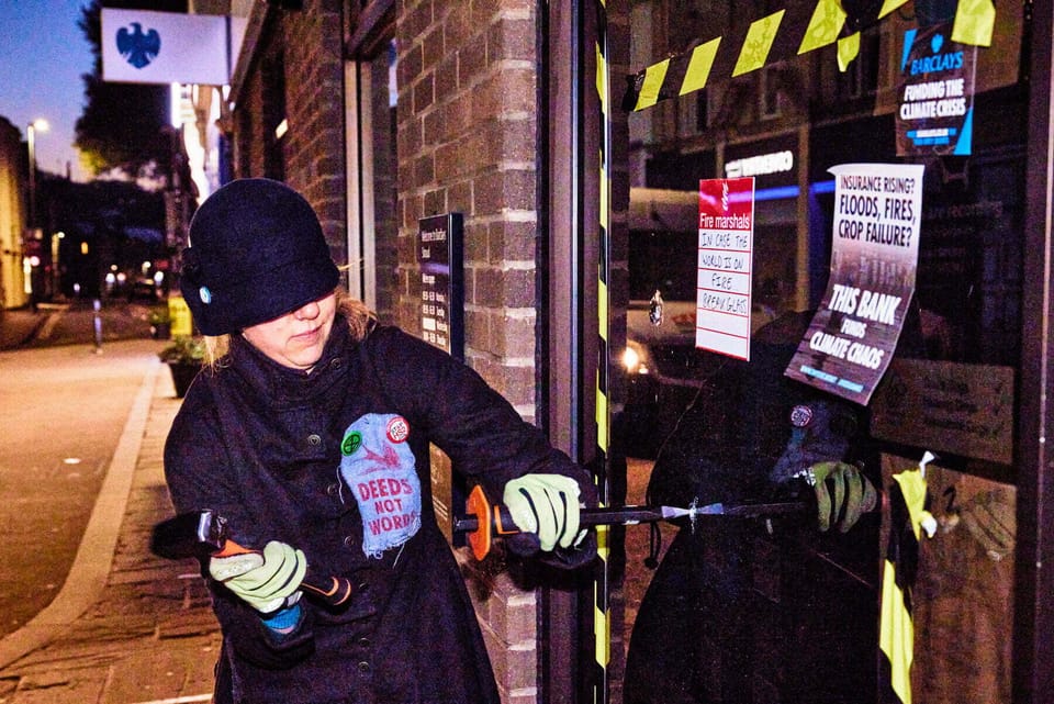 XR co-founder protests funding of polluting industries by breaking window at Barclays Bank in Stroud